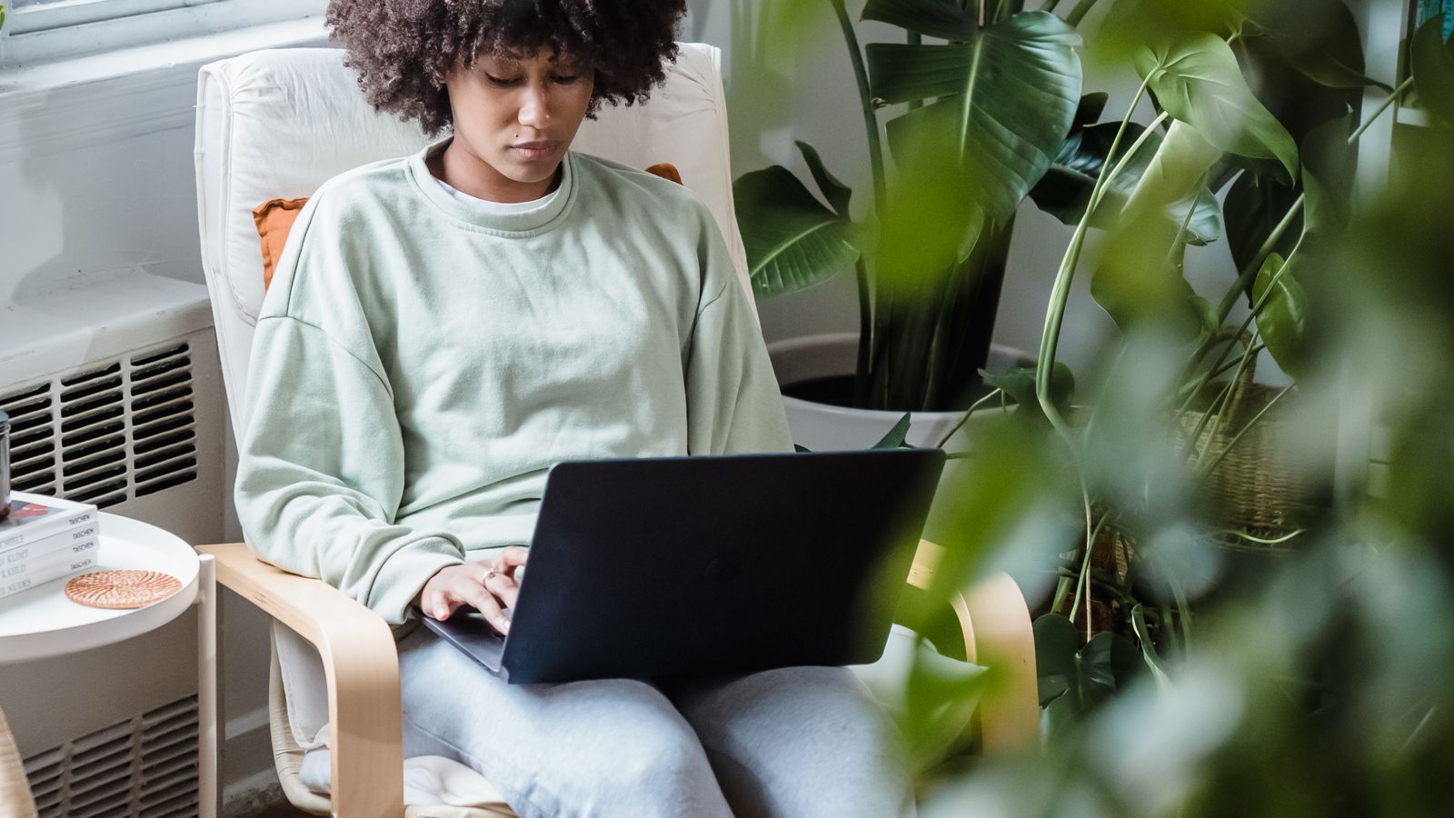 Virtual scrapbook pages being reviewed on a laptop screen in a bright home workspace