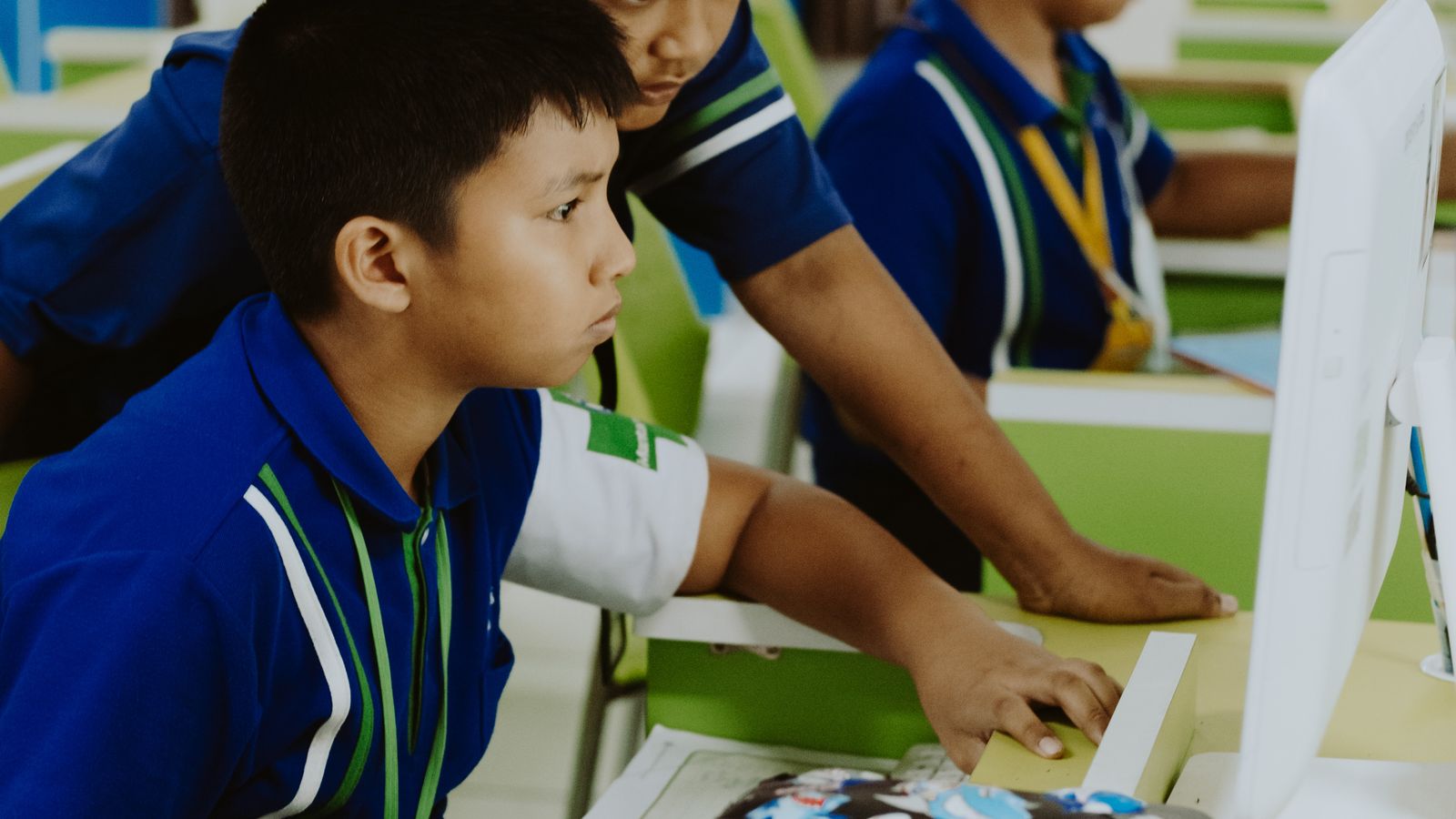 Students using an online yearbook maker on classroom computers